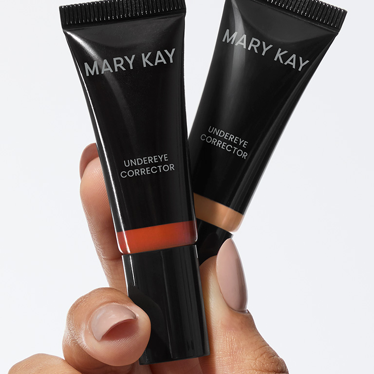 Mano sosteniendo ambos tonos del corrector de ojeras Mary Kay